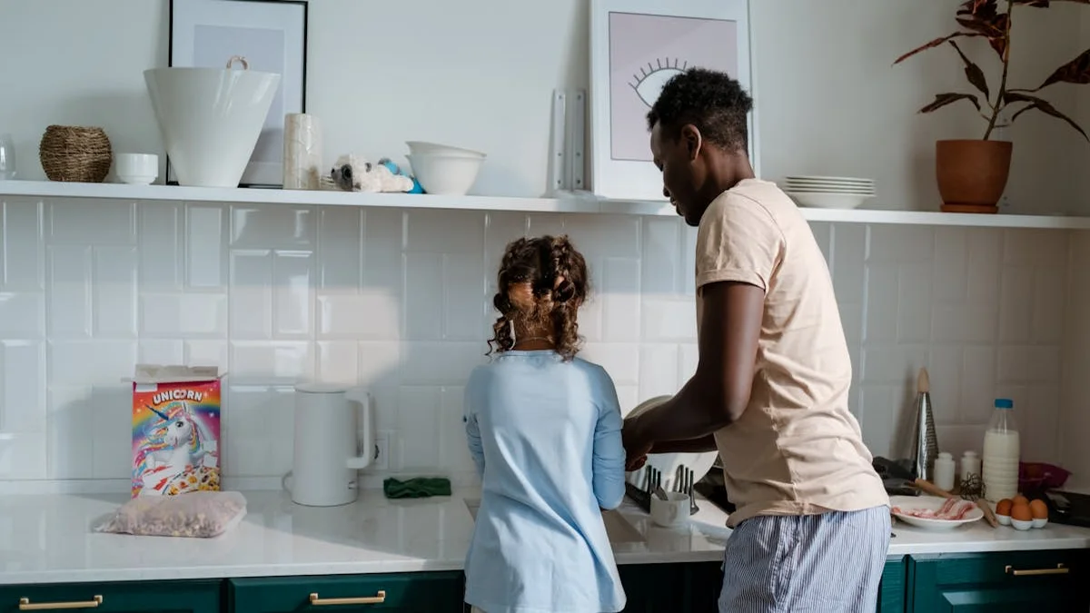 A parent and child reviewing a chore chart on a tablet in a sunny kitchen