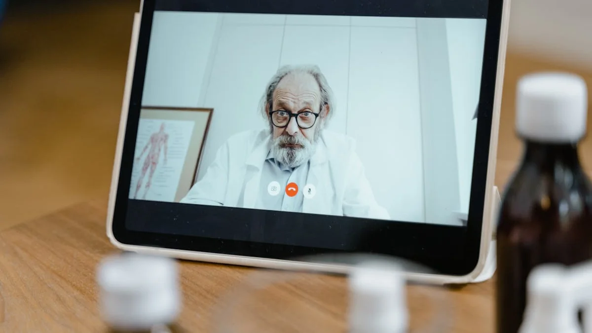 A senior shows a medical ID card on a tablet during a doctor's visit