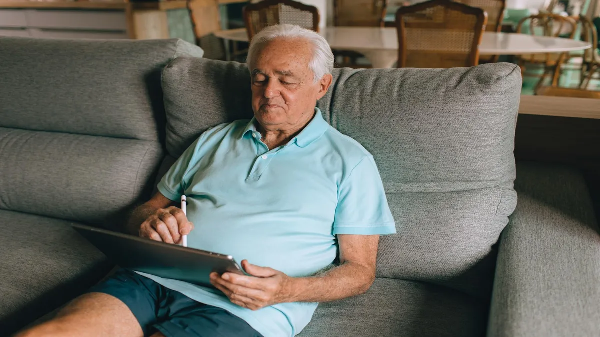 Senior confidently using a tablet-based medication tracker at home